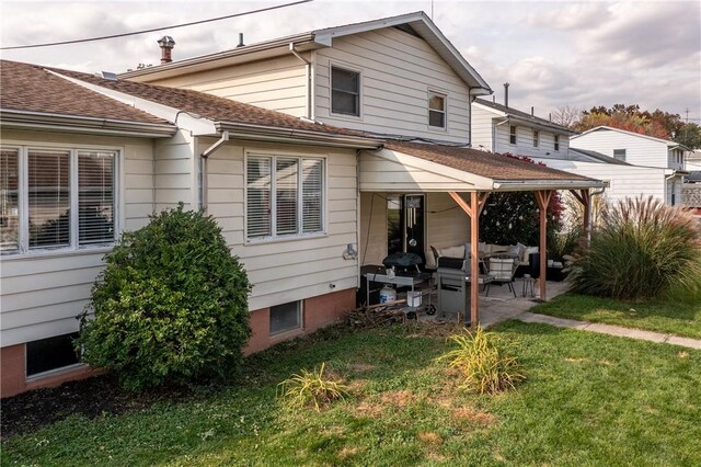 back of house with a lawn, a patio area, and an outdoor hangout area