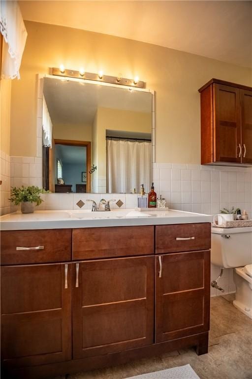 bathroom featuring tasteful backsplash, vanity, and toilet