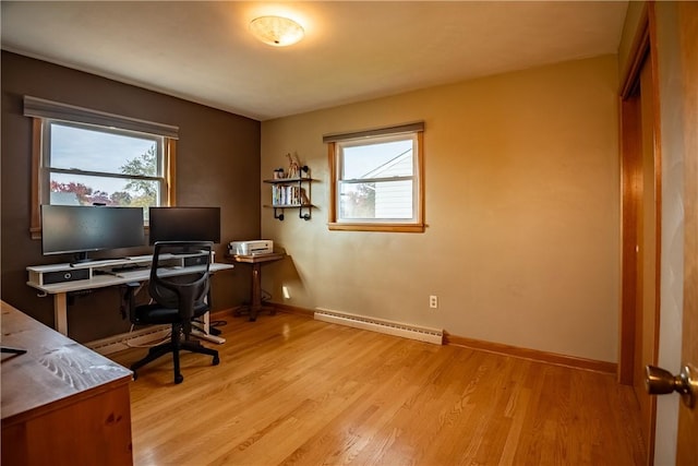 home office with baseboard heating, a healthy amount of sunlight, and light wood-type flooring