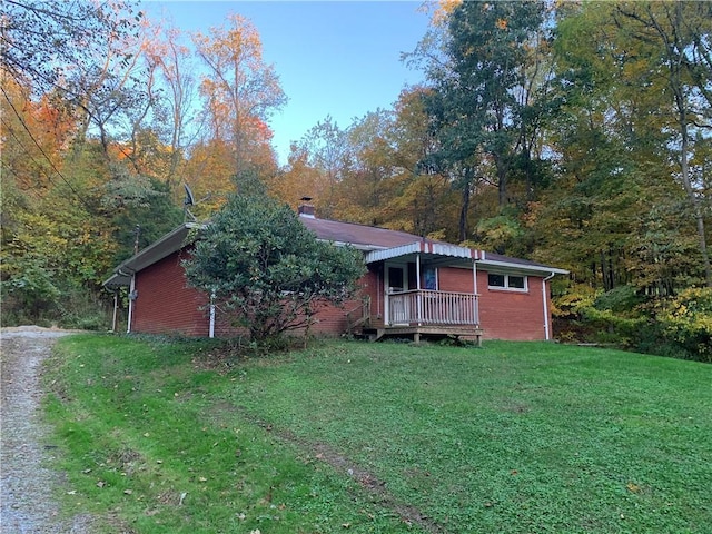 561 Williams Ave, Rochester Twp, PA 15074 - rear view of house featuring a lawn, a chimney, a wooded view, and brick siding