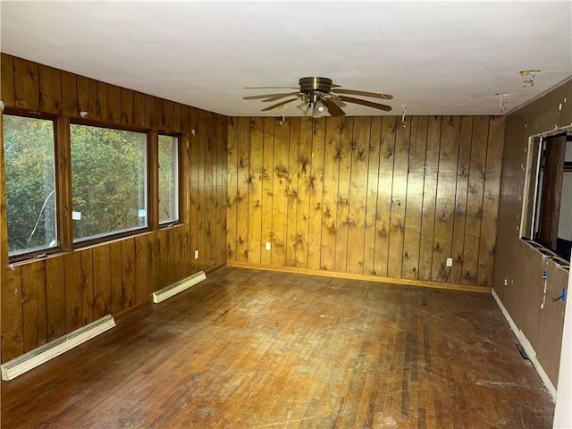 561 Williams Ave, Rochester Twp, PA 15074 - empty room featuring baseboard heating, a ceiling fan, hardwood / wood-style floors, and wooden walls