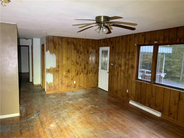 561 Williams Ave, Rochester Twp, PA 15074 - unfurnished room with a baseboard heating unit, wooden walls, ceiling fan, and wood finished floors