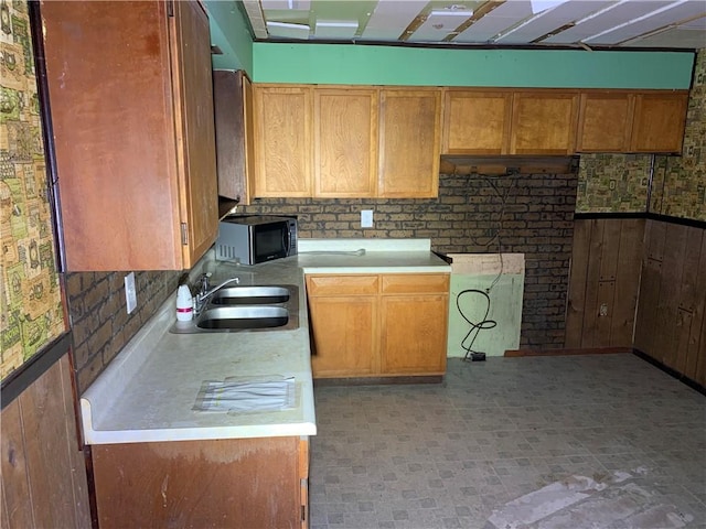 561 Williams Ave, Rochester Twp, PA 15074 - kitchen with black microwave, light countertops, wooden walls, a wainscoted wall, and light flooring