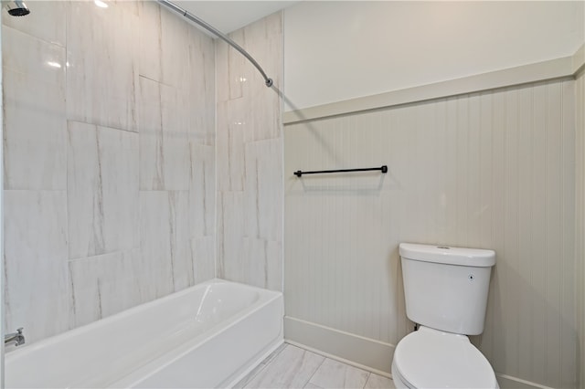 bathroom featuring tiled shower / bath combo and toilet