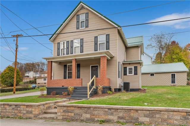 front of property with a front yard, covered porch, and central AC unit