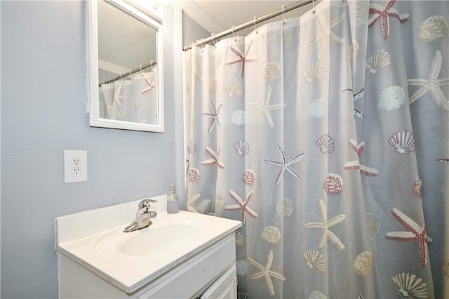 bathroom featuring vanity, ornamental molding, and walk in shower