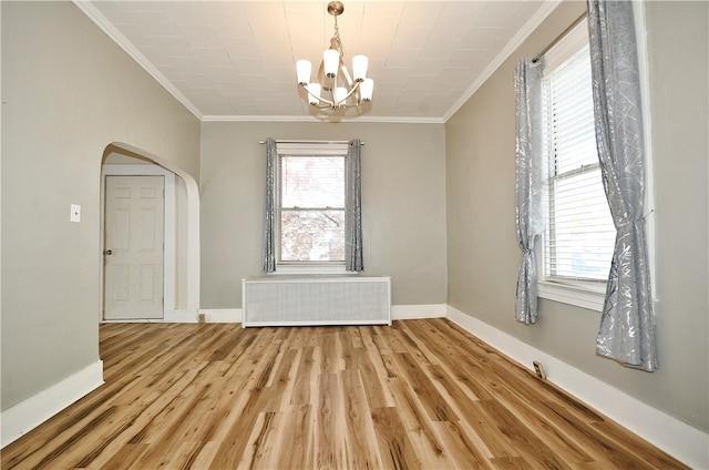 unfurnished room featuring ornamental molding, a chandelier, radiator heating unit, and hardwood / wood-style flooring