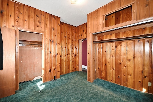 unfurnished bedroom with wooden walls and dark carpet