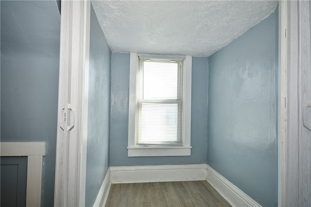 unfurnished room with wood-type flooring and a textured ceiling