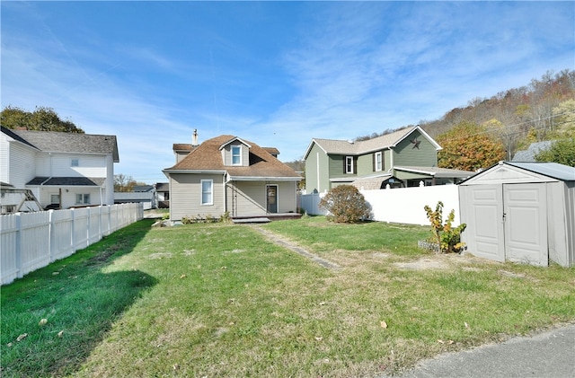 rear view of house with a shed and a yard