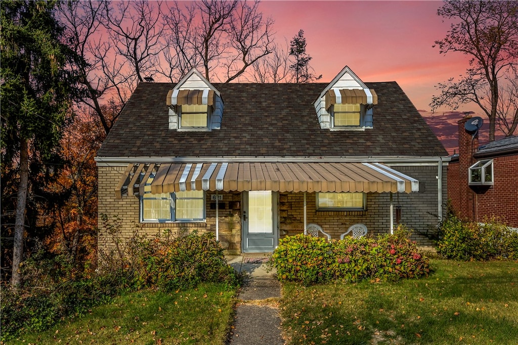 new england style home featuring a lawn