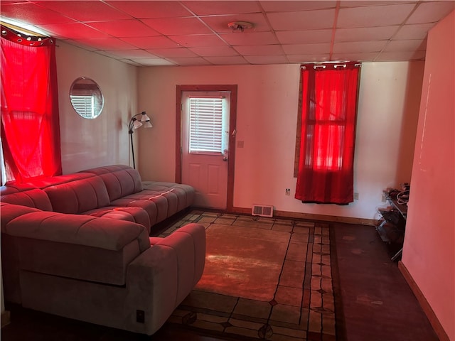 tiled living room featuring a drop ceiling