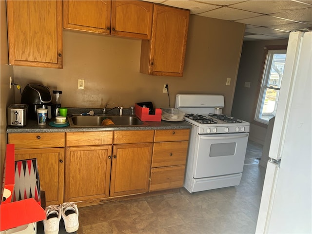 kitchen featuring sink, a paneled ceiling, and white appliances