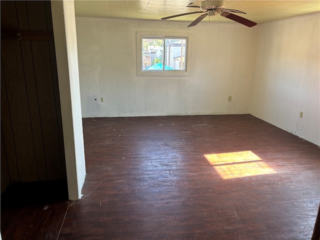 spare room featuring dark wood-type flooring and ceiling fan