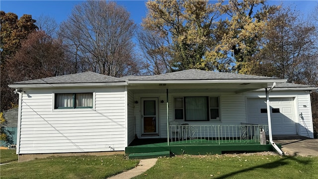 view of front of home featuring covered porch, a front lawn, and a garage