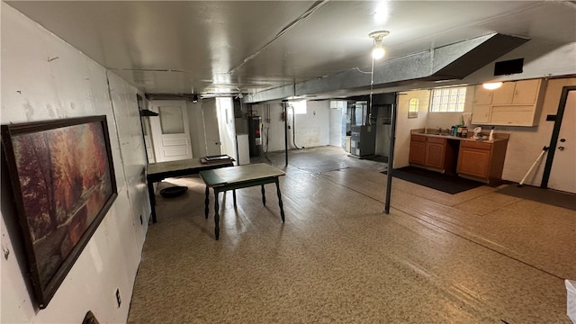 basement with sink, water heater, and heating unit