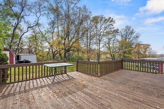 wooden terrace featuring a yard and a shed