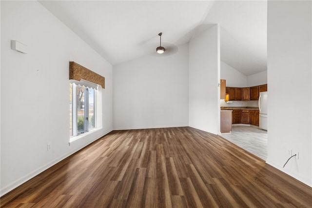 unfurnished living room featuring high vaulted ceiling and wood-type flooring