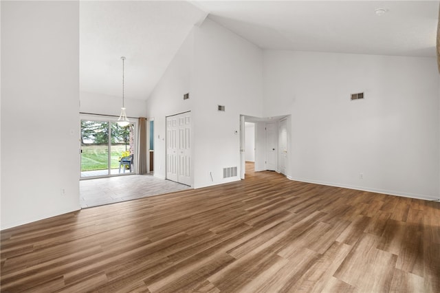 unfurnished living room with high vaulted ceiling and hardwood / wood-style flooring