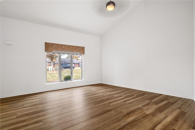 unfurnished room with dark wood-type flooring and lofted ceiling