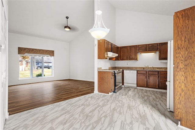 kitchen featuring hanging light fixtures, white appliances, sink, vaulted ceiling, and light hardwood / wood-style floors