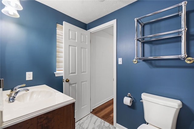 bathroom featuring vanity, toilet, a textured ceiling, and hardwood / wood-style floors