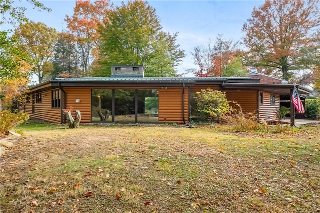 rear view of property with a lawn