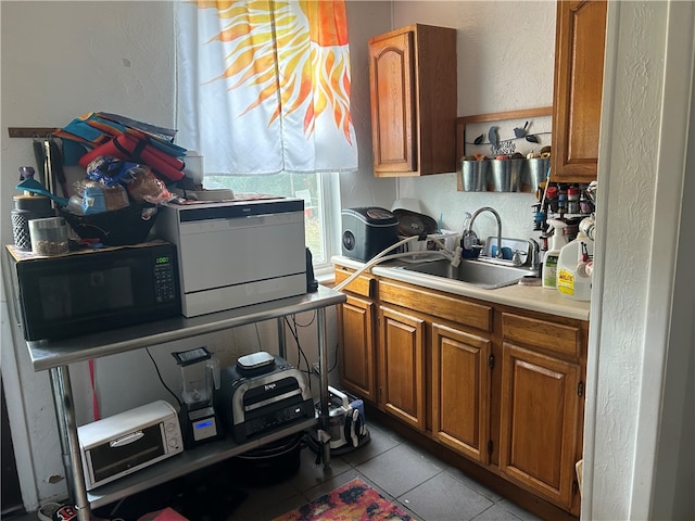 kitchen featuring light tile patterned floors and sink