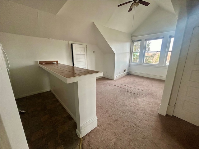 additional living space with vaulted ceiling, carpet flooring, and ceiling fan