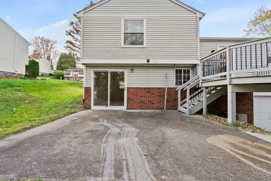 back of property with a yard and a garage