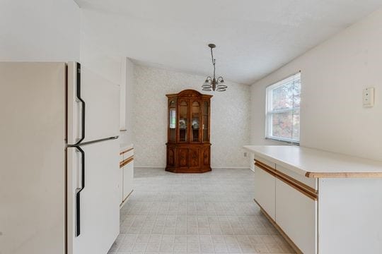 dining room with vaulted ceiling and a notable chandelier