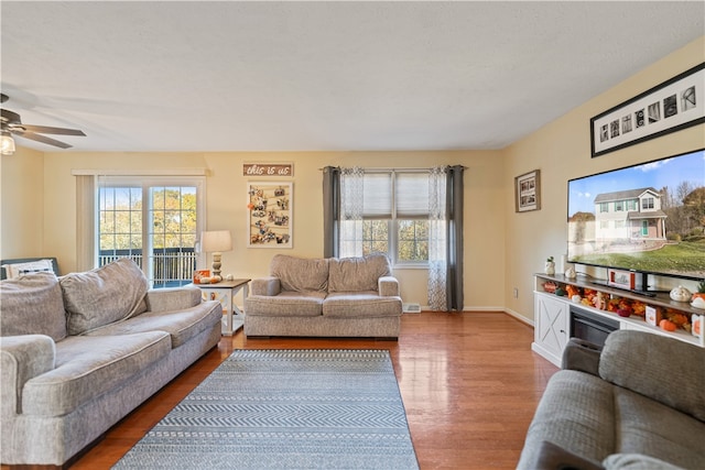 living room featuring ceiling fan, plenty of natural light, and hardwood / wood-style flooring