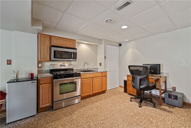 kitchen featuring a paneled ceiling, stainless steel appliances, and sink