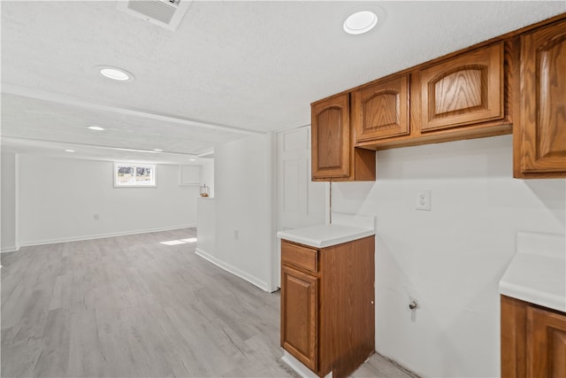 kitchen with a textured ceiling and light wood-type flooring