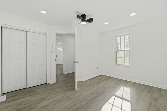 unfurnished bedroom featuring light wood-type flooring, a closet, and ceiling fan