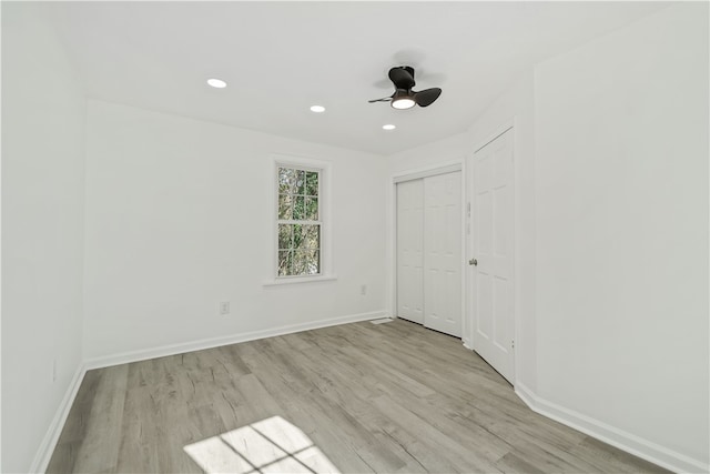 unfurnished bedroom featuring a closet, light wood-type flooring, and ceiling fan