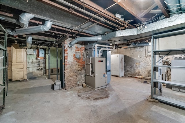 basement with electric panel, heating unit, and white refrigerator