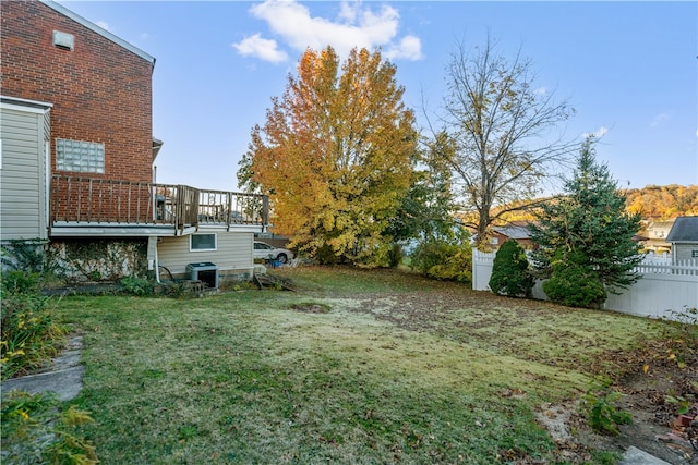 view of yard with central air condition unit and a wooden deck