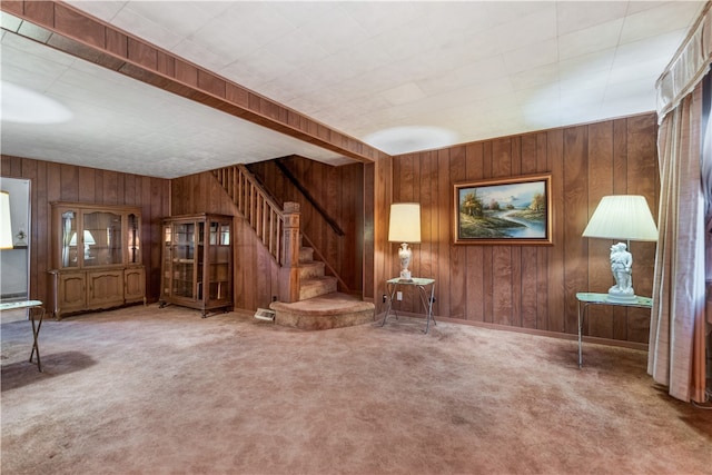 unfurnished living room with wooden walls and carpet