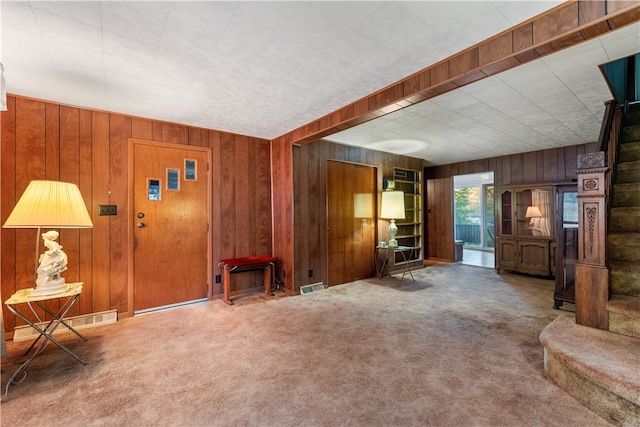 unfurnished living room with wooden walls and carpet floors