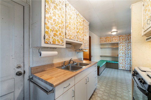 kitchen with sink, white cabinetry, and white electric stove