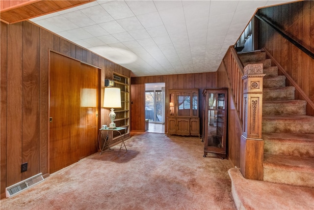 interior space featuring carpet floors and wood walls