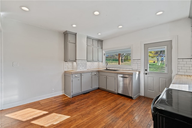 kitchen featuring gray cabinetry, range, dishwasher, and dark hardwood / wood-style floors