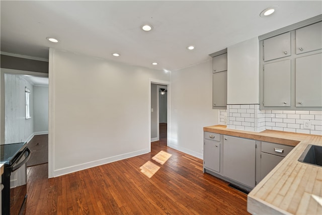 kitchen with gray cabinets, dark wood-type flooring, and butcher block countertops