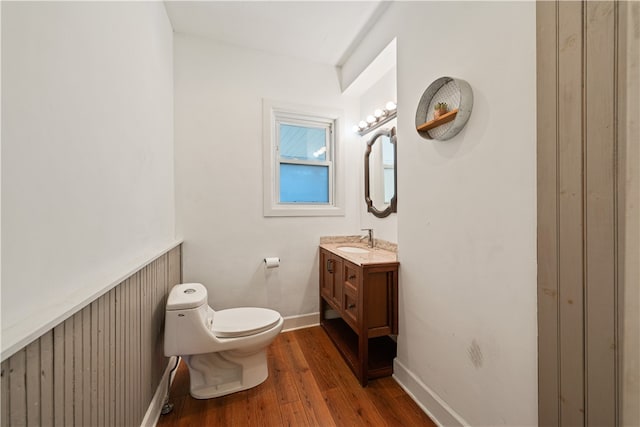 bathroom featuring vanity, toilet, wood walls, and wood-type flooring