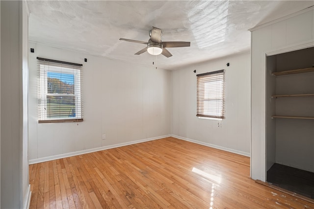 unfurnished bedroom featuring light hardwood / wood-style flooring, multiple windows, and ceiling fan