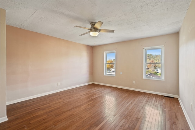 empty room featuring a textured ceiling, hardwood / wood-style flooring, and ceiling fan