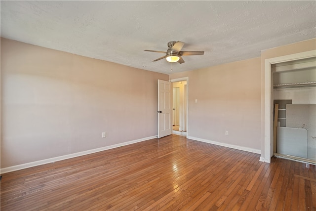 unfurnished bedroom featuring a closet, a textured ceiling, hardwood / wood-style flooring, and ceiling fan