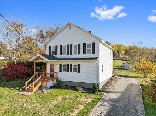 view of property featuring covered porch and a front yard