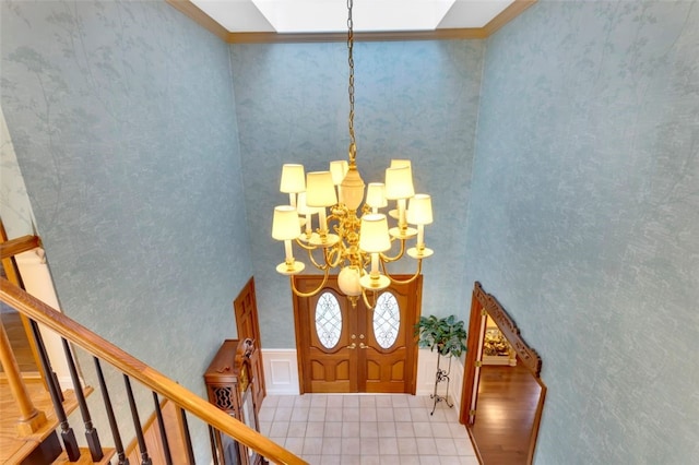 foyer featuring hardwood / wood-style floors, crown molding, and a chandelier